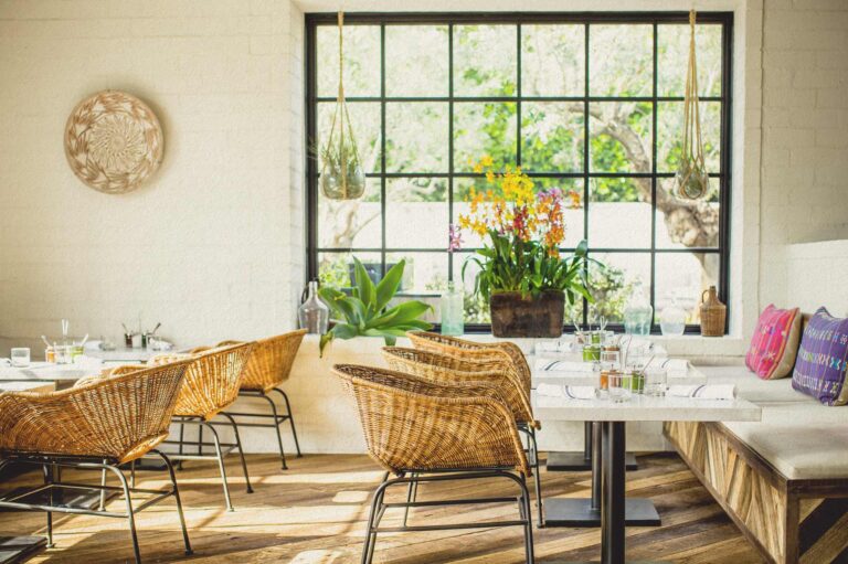 Lounge tables and wicker chairs inside Gracias Madre West Hollywood.