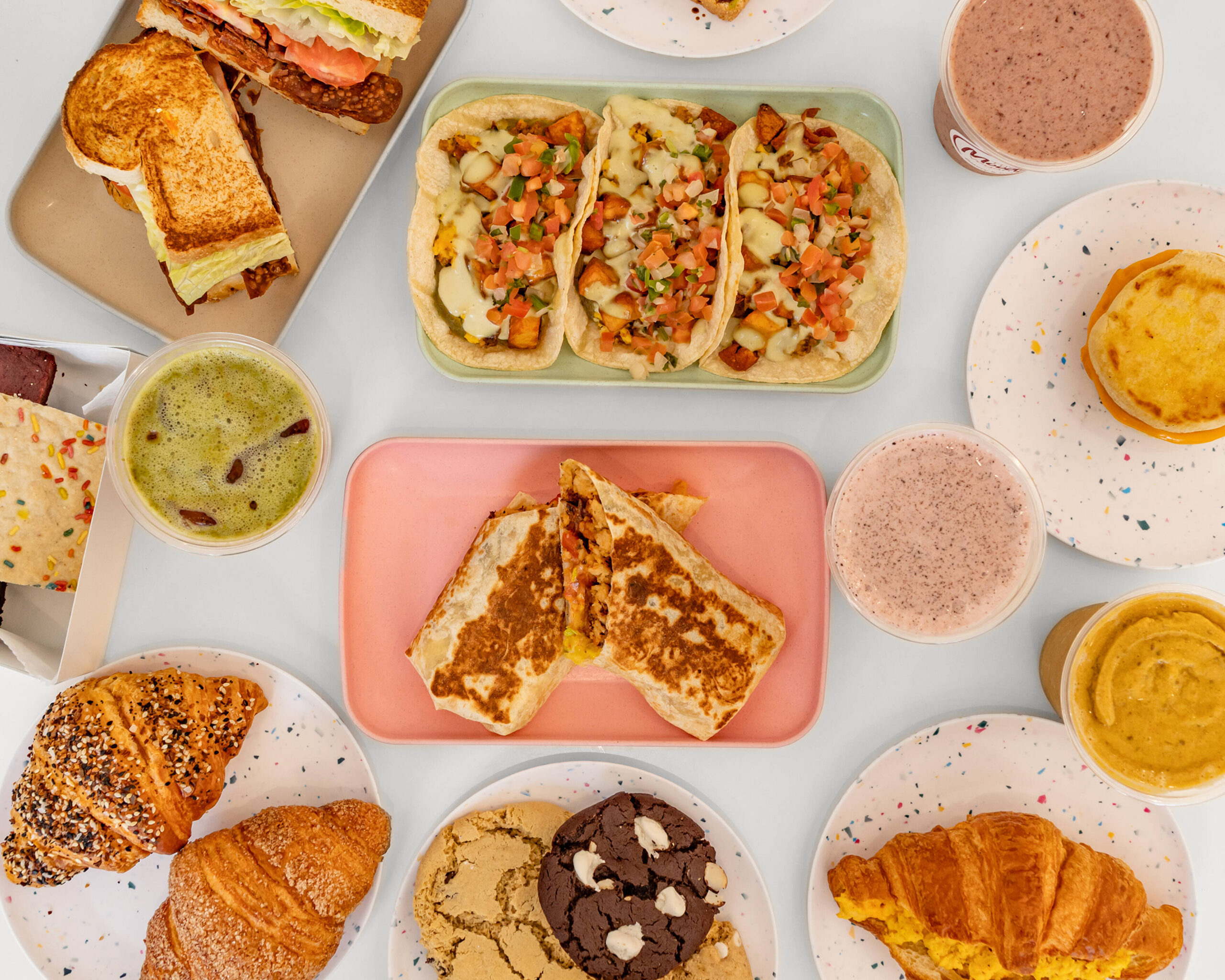 A spread of vegan breakfast, pastry, taco, drink, and cookie options from The Moody Vegan.