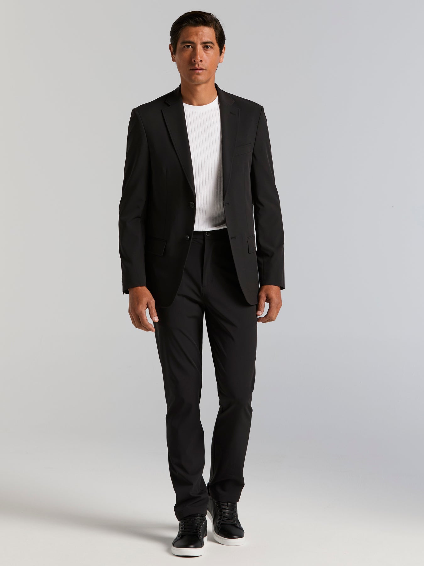 Full-body view of a Perry Ellis black tech suit on a model.