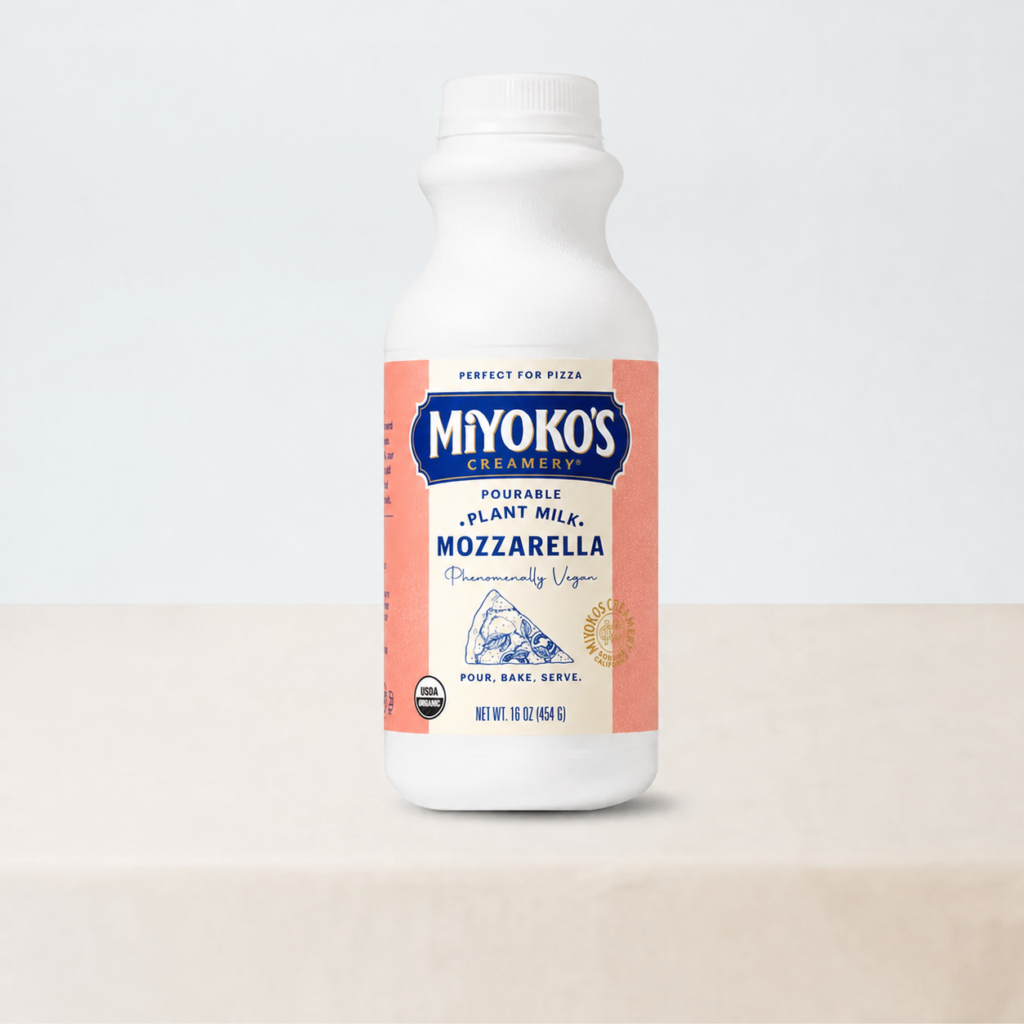 Bottle of Miyoko's pourable plant milk mozzarella on a pale studio background.