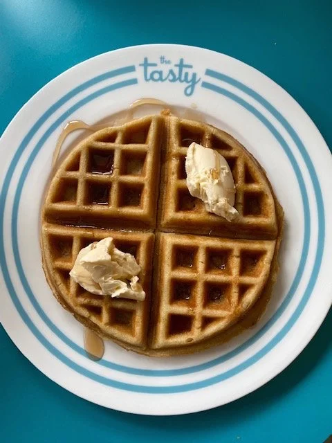 A waffle with vegan butter and syrup at The Tasty.