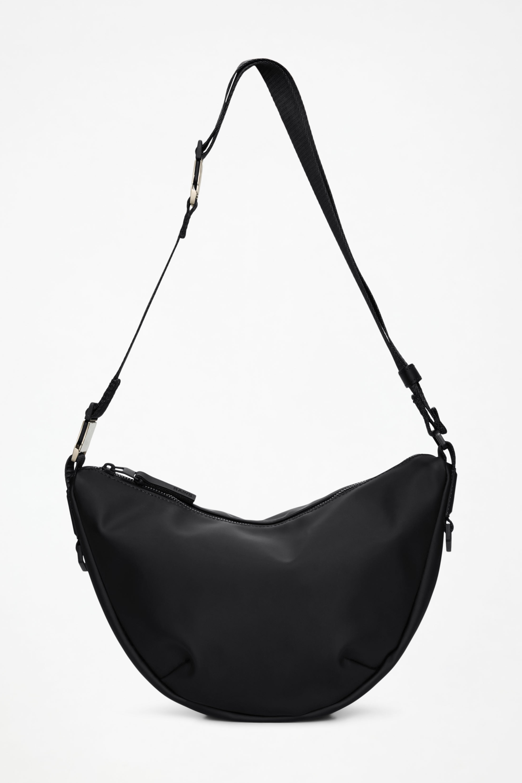 Black Rains Valera Shoulder Bag with a matte curved body, coated zipper, webbing strap, and silver-tone hardware.