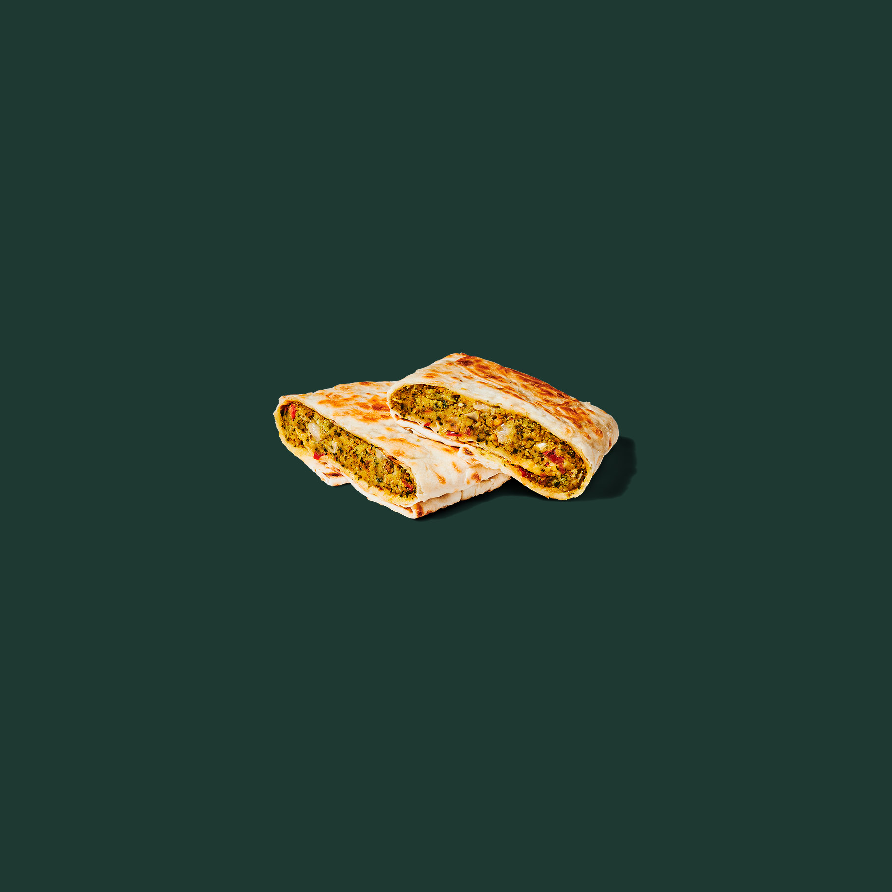 Starbucks Spicy Falafel Pocket cut open to show falafel, hummus, roasted red pepper, and pickled onions.